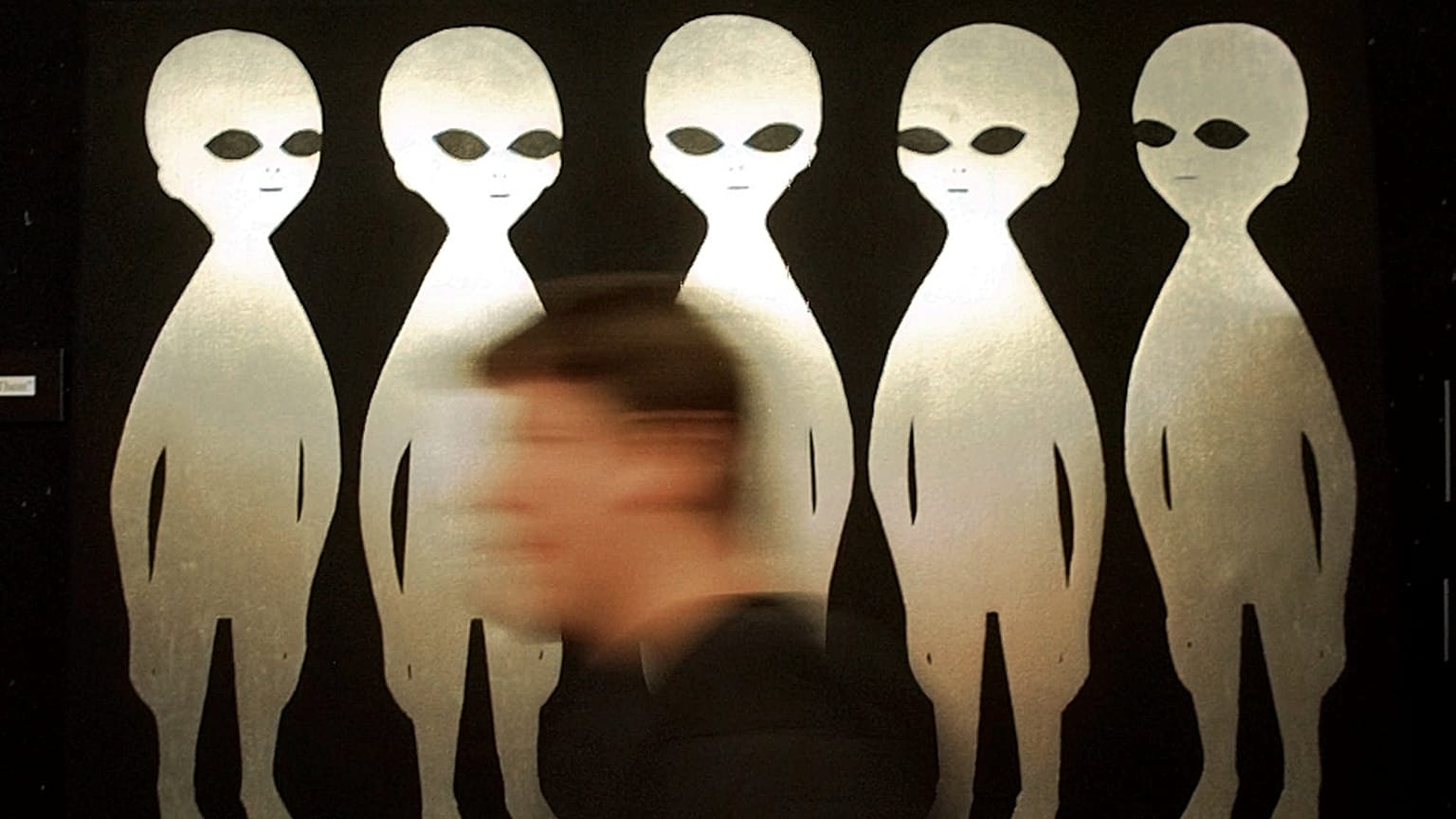 FILE: A patron passes a painting inside the International UFO Museum and Research Center in Roswell, N.M., Tuesday, June 10, 1997. 