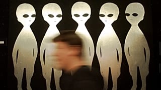FILE: A patron passes a painting inside the International UFO Museum and Research Center in Roswell, N.M., Tuesday, June 10, 1997.