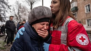 Eine Rettungshelferin tröstet eine Frau, nachdem russische Raketen Wohnhäuser in Kryvyi Rih verwüstet haben. 