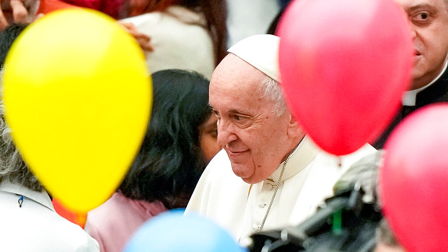Pope Francis greets children at the end of an audience with children assisted by the Santa Marta dispensary in the Paul VI Hall, at the Vatican, Sunday, Dec. 18, 2022. 