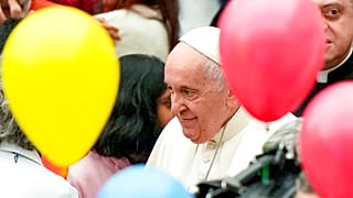 Pope Francis greets children at the end of an audience with children assisted by the Santa Marta dispensary in the Paul VI Hall, at the Vatican, Sunday, Dec. 18, 2022. 