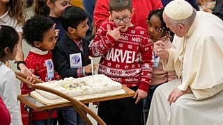 Un niño prueba la tarta de cumpleaños del papa