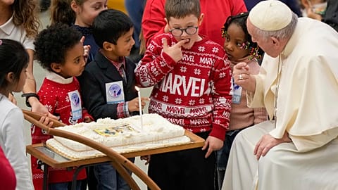 Un niño prueba la tarta de cumpleaños del papa