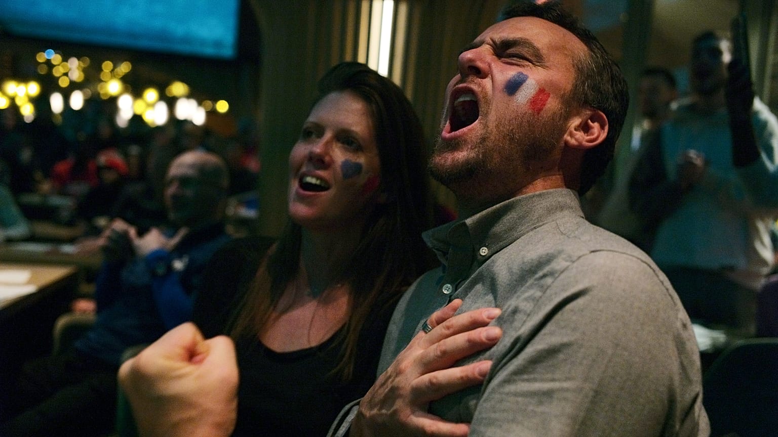 Fans sing "La Marsellaise," the French national anthem, in Paris as their team scores a third goal. 