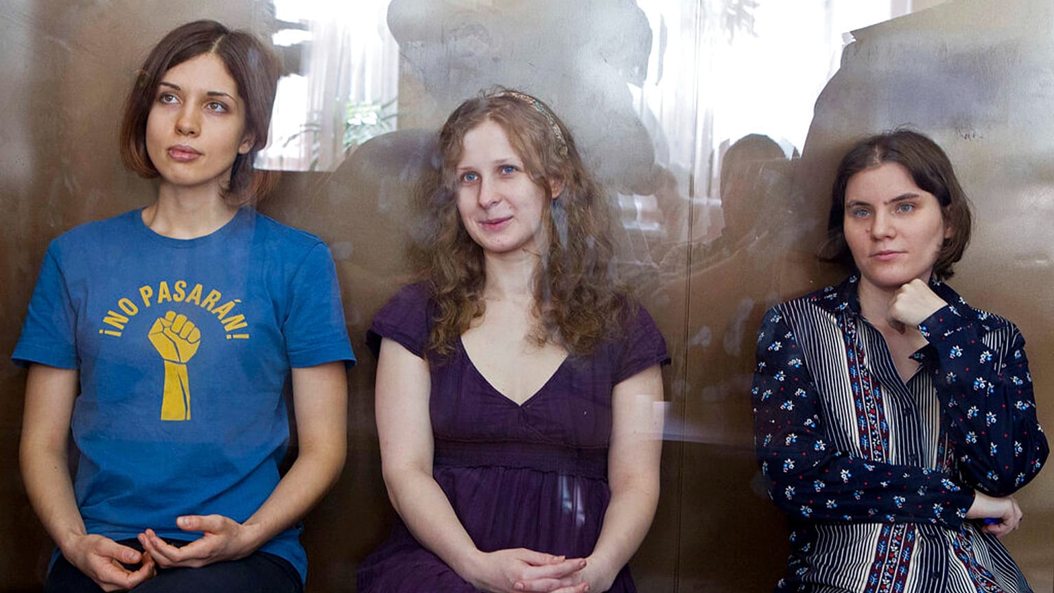Feminist punk grubu Pussy Riot üyeleri (soldan Nadezhda Tolokonnikova, Maria Alekhina, Yekaterina Samutsevich) Moskova'da bir mahkemede cam kafes içinde otururken (arşiv)