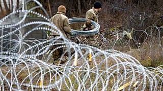 US soldiers serving in NATO-led peacekeeping force KFOR, place a barbed wire at a checkpoint near the northern Kosovo border crossing Sunday, Dec. 18, 2022.