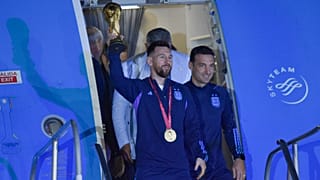 ميسي رافعاً الكأس عند نزوله من الطائرة في بوينس آيرس 