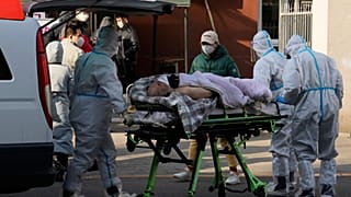 مردی مسن بر روی برانکارد در جلوی یک کلینگ تب در شهر پکن به تاریخ ۹ دسامبر ۲۰۲۲