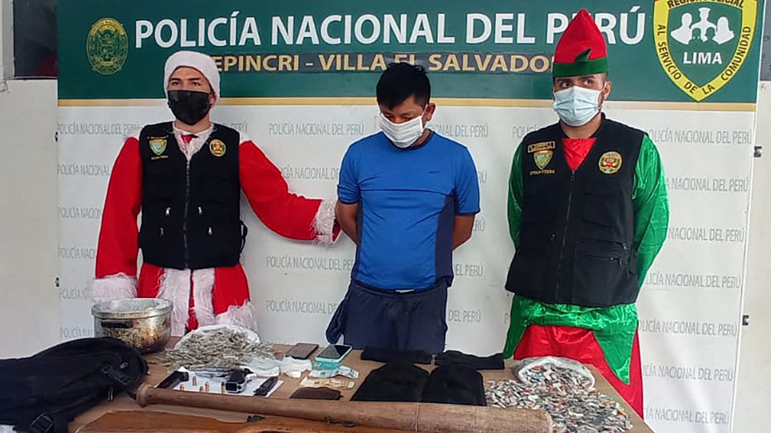 Polícias disfarçados de Pai Natal e duende de Natal com um traficante detido
