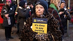 A supporter of nurses' strike and NHS holds a placard at a picket line outside St Mary's Hospital in west London on December 15, 2022