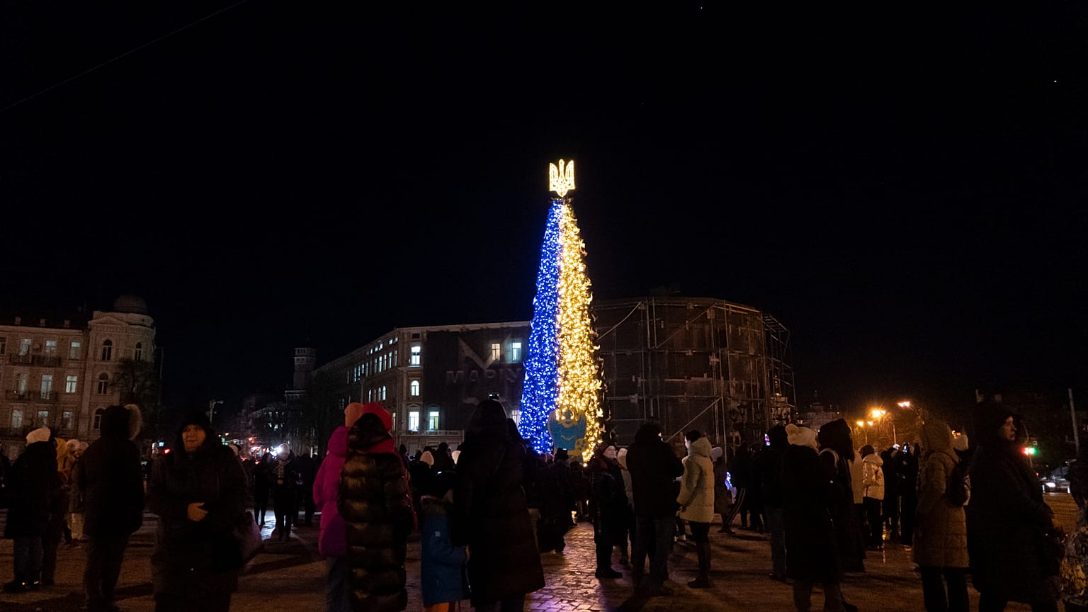 People attend the inauguration of a Christmas tree decorated with the colours of the Ukrainian national flag in Kyiv, Ukraine, Monday, Dec. 19, 2022