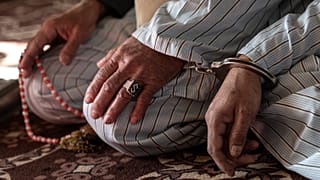 رجل أفغاني محكوم عليه بالإعدام بتهمة القتل، مكبل اليدين إلى سجين آخر، خلال جلسة استماع في محكمة استئناف غزني، في شرق أفغانستان. 2022/11/28