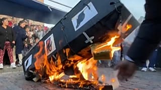 Protesters burn cardboard coffin depicting pictures of politicians and rats in Cusco, Peru.