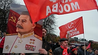 عضو من الحزب الشيوعي الروسي رافعاً صورة للقائد السوفياتي السابق جوزيف ستالين 