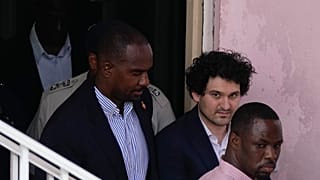 File from December 19 shows FTX founder Sam Bankman-Fried, second right, is escorted out of Magistrate Court toward a Corrections van, following a hearing in Nassau, Bahamas