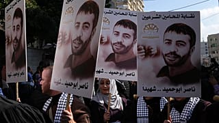 Filistinli göstericiler, İsrail'de bir hapishanede hayatını kaybeden Filistinli Nasır Ebu Hamid'in posterlerini taşırken