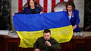 La vicepresidenta Kamala Harris y la presidenta de la Cámara de Representantes, Nancy Pelosi, sujetan una bandera ucraniana firmada por las tropas en Bajmut