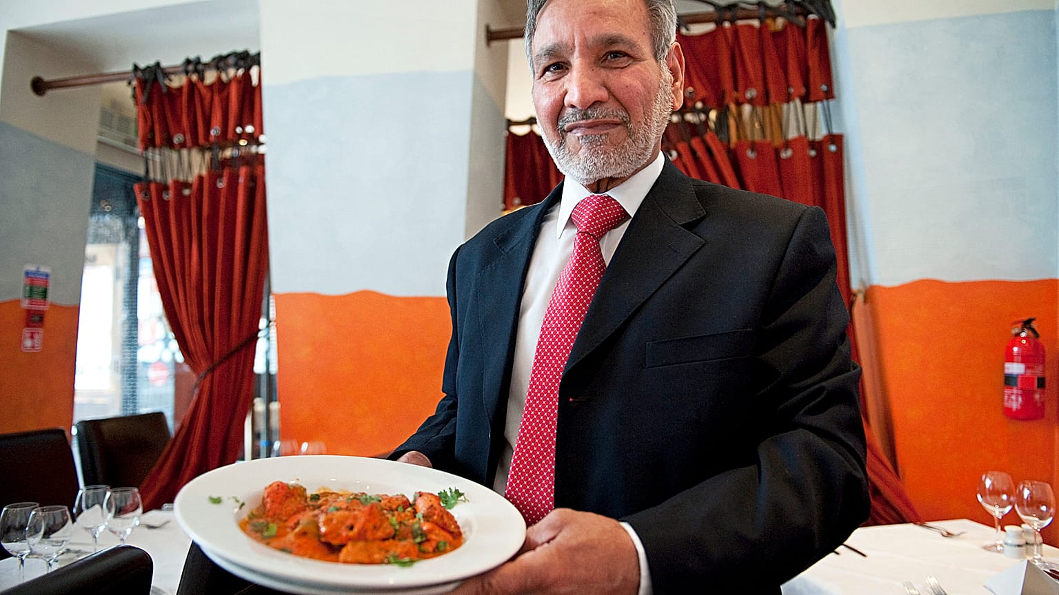 Ahmed Aslam Ali, the owner of the Shish Mahal restaurant in Glasgow, is pictured with a plate of Chicken Tikka Masala in his restaurant, on July 29, 2009. 