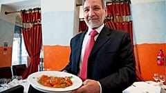 Ahmed Aslam Ali, the owner of the Shish Mahal restaurant in Glasgow, is pictured with a plate of Chicken Tikka Masala in his restaurant, on July 29, 2009. 