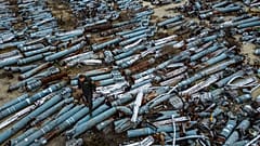 Un procureur observe des pièces collectées de roquettes russes utilisées pour attaquer la ville de Kharkiv, Ukraine, jeudi 22 décembre 2022. 