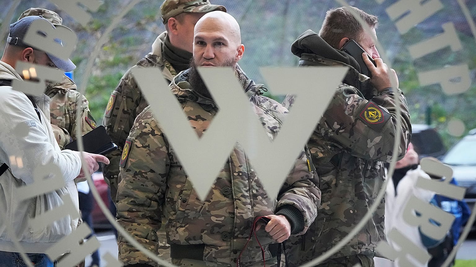 Visitors wearing military camouflage stand at the entrance of the 'PMC Wagner Centre' in St Petersburg, 4 November 2022