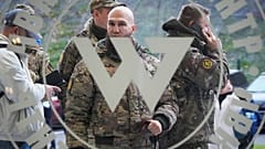 Visitors wearing military camouflage stand at the entrance of the 'PMC Wagner Centre' in St Petersburg, 4 November 2022