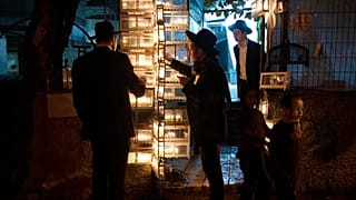 Ultraortodox zsidó szemináriumi hallgatók gyertyát gyújtanak hanuka ötödik estéjén Jeruzsálem Mea Shearim negyedében 2022. december 22-én