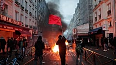 members of Kurdish community waves the Kurdish communist flags next to a barricade on fire at the crime scene where a shooting took place in Paris, Friday, Dec. 23, 2022. 