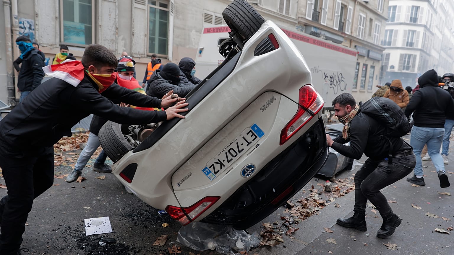 Manifestantes vuelcan un coche durante una protesta contra el reciente tiroteo en el centro cultural kurdo de París, el 24 de diciembre de 2022. 