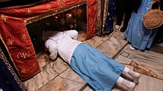 Egy apáca megcsókolja a Jézus születési helyét jelölő csillagot a betlehemi Születés Templomában