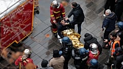 Медики пожарной бригады эвакуируют на носилках раненого участника протестов, вспыхнувших после стрельбы у курдского культурного центра, 24 декабря 2022 года.