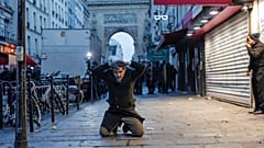 Ein Kurde kniet auf dem Boden, als er bei Zusammenstößen mit Polizeibeamten in der Nähe des Tatorts einer Schießerei in Paris festgenommen wird