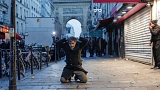 Ein Kurde kniet auf dem Boden, als er bei Zusammenstößen mit Polizeibeamten in der Nähe des Tatorts einer Schießerei in Paris festgenommen wird