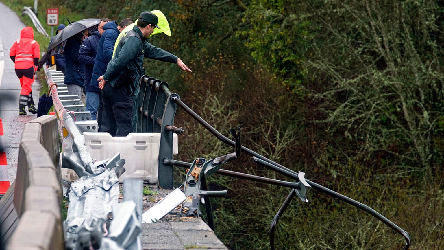A civil guard points toward a bus after it plunged into a river near Pontevedra in northwestern Spain, Sunday, Dec. 25, 2022.