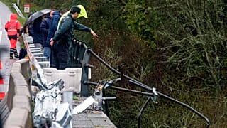 A civil guard points toward a bus after it plunged into a river near Pontevedra in northwestern Spain, Sunday, Dec. 25, 2022.
