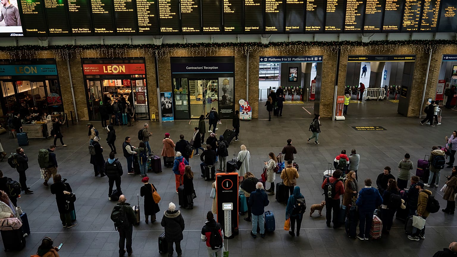 Varias personas se preparan para subir a un tren en la estación londinense de Kings Cross, el sábado 24 de diciembre de 2022.
