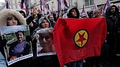 Activistas kurdas sostienen banderas y retratos mientras marchan en honor a las víctimas mortales del tiroteo sucedido en París. 