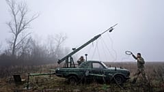 Ukrán katonák egy teleszkópos toronyra szerelt kamerát állítanak fel egy Volga platójára a kelet-ukrajnai Harkiv közelében húzódó frontvonalnál 2022. december 25-én.