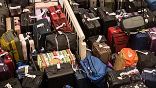 Hundreds of unclaimed suitcases and a box wrapped in Christmas wrapper sit near the baggage carousel at Midway Airport in Chicago, 27 December 2022