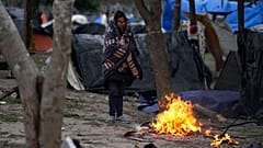A migrant stands in the cold weather around a fire at a makeshift camp on the U.S.-Mexico border in Matamoros, Mexico. 