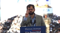 Gabriel Borić chilei elnök a megsemmisítésre váró fegyverhalom előtt 2022. december 27-én Santiago de Chilében