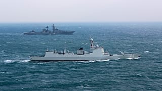 Chinese navy destroyer Jinan, foreground, sails along with Russian navy cruiser Varyag during a joint naval drills in the East China Sea on 21 December 2022