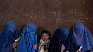 Mujeres afganas esperan para recibir dinero en un punto de distribución organizado por el Programa Mundial de Alimentos, en Kabul, Afganistán.