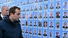 French Armies Minister Sebastien Lecornu (L) and French Ambassador to Ukraine Etienne de Poncins (R) stand in front of the Memorial Wall of Fallen Defenders of Ukraine in Kyiv