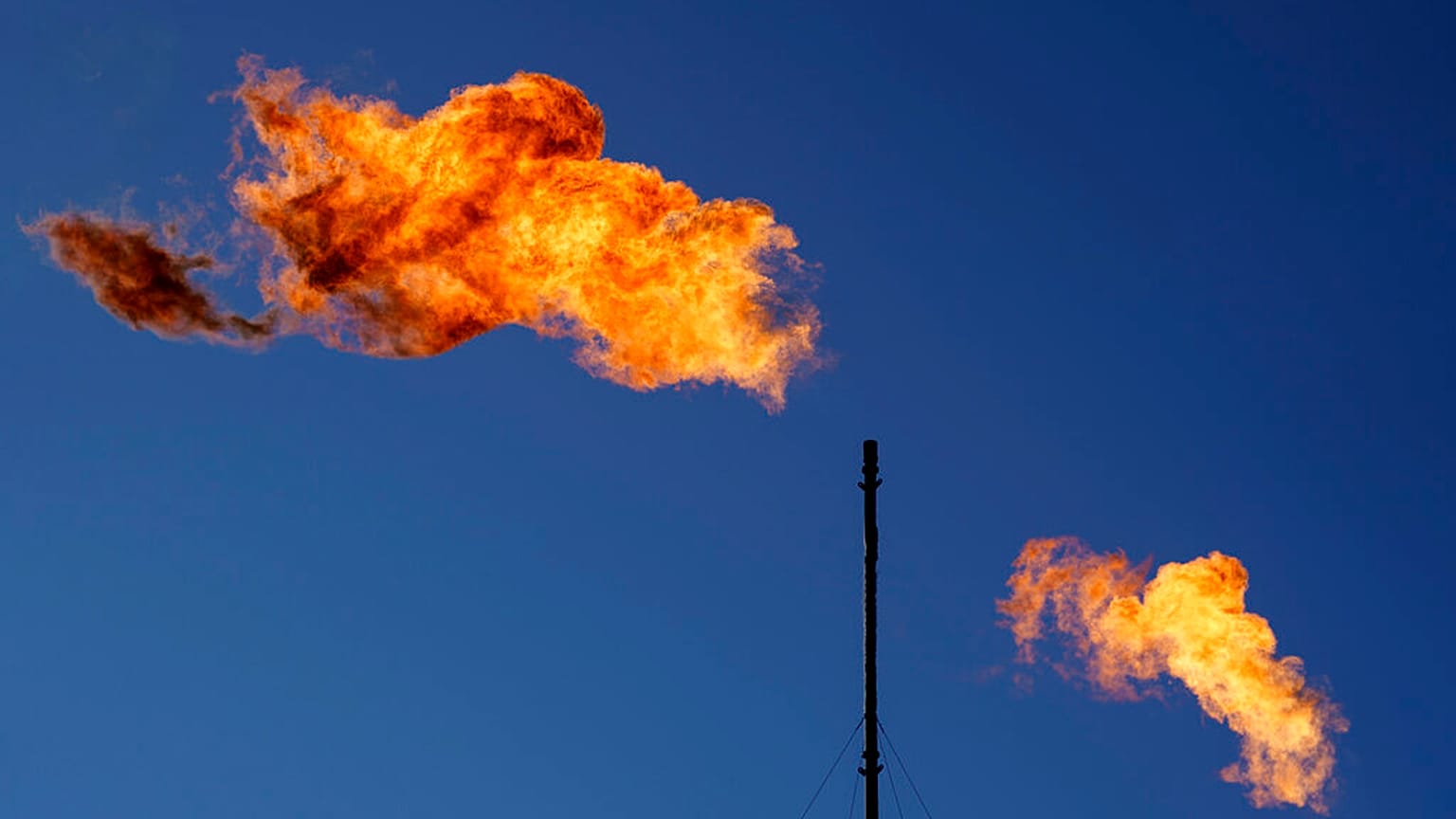 Flares burn off methane and other hydrocarbons at an oil and gas facility in Lenorah, Texas, Oct. 15, 2021