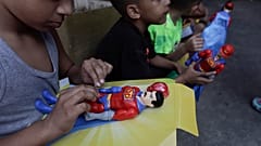 Kinder spielen mit "Super Bigote"-Puppen im Carayaca-Viertel von La Guaira, Venezuela