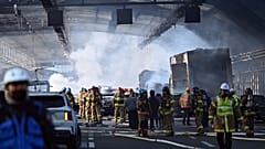 Pompiers  et secouristes sur les lieux d'incendie qui s'est déclaré dans un un tunnel autoroutier à Seoul, le 29 décembre 2022