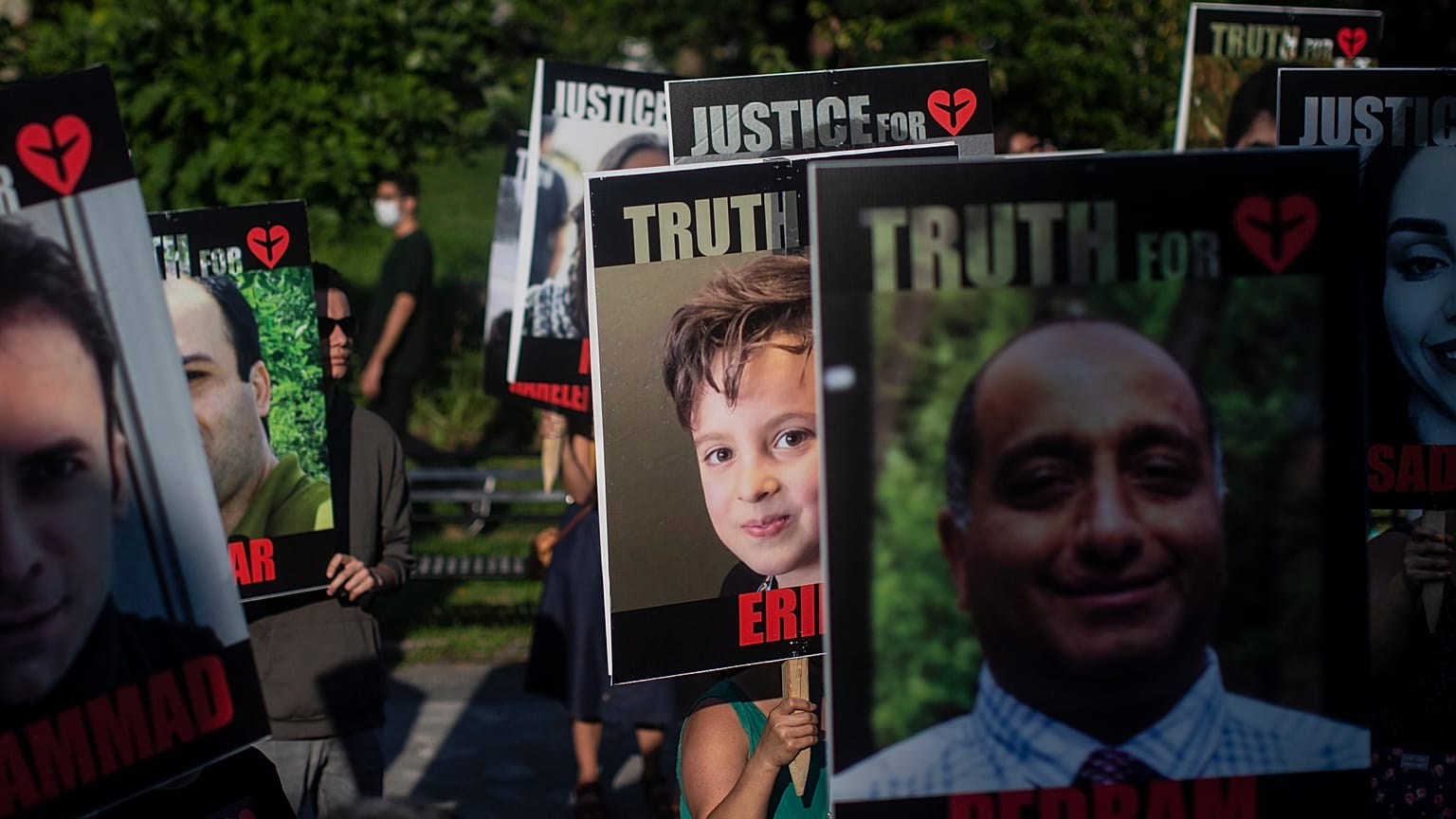 Placards bearing the faces of the victims of Flight PS752 are carried in Toronto.