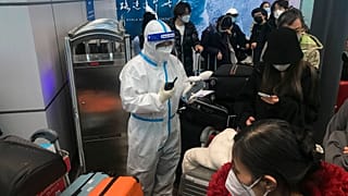 Ankommende Reisende warten stundenlang an Bord von Bussen, die sie vom Flughafen Guangzhou Baiyun in der südchinesischen Provinz Guangdong zu Quarantänehotels