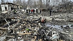 Des sauveteurs enlèvent les débris des maisons détruites par une attaque de missiles dans la banlieue de Kiev, le 29 décembre 2022.